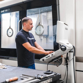 Unterschütz Mitarbeiter Tom Scheffler an CNC-Maschine in Produktionshalle