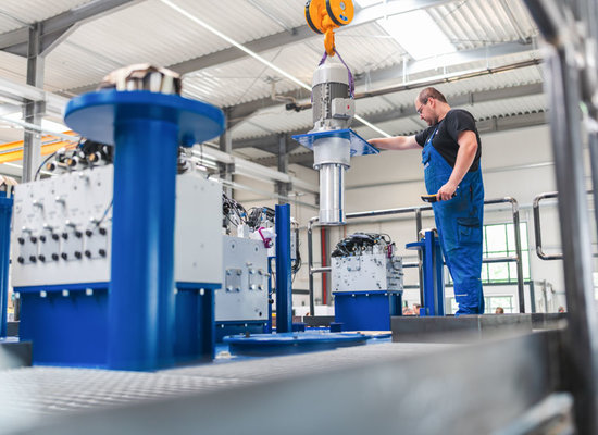 Mitarbeiter installiert hydraulische Komponenten bei Unterschütz Maschinen- und Anlagenbau