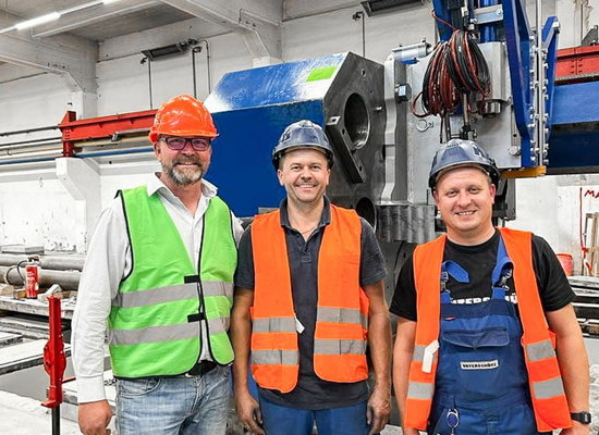 drei Unterschütz-Mitarbeiter in Warnwesten und Helmen vor einer zu inspizierenden Anlage