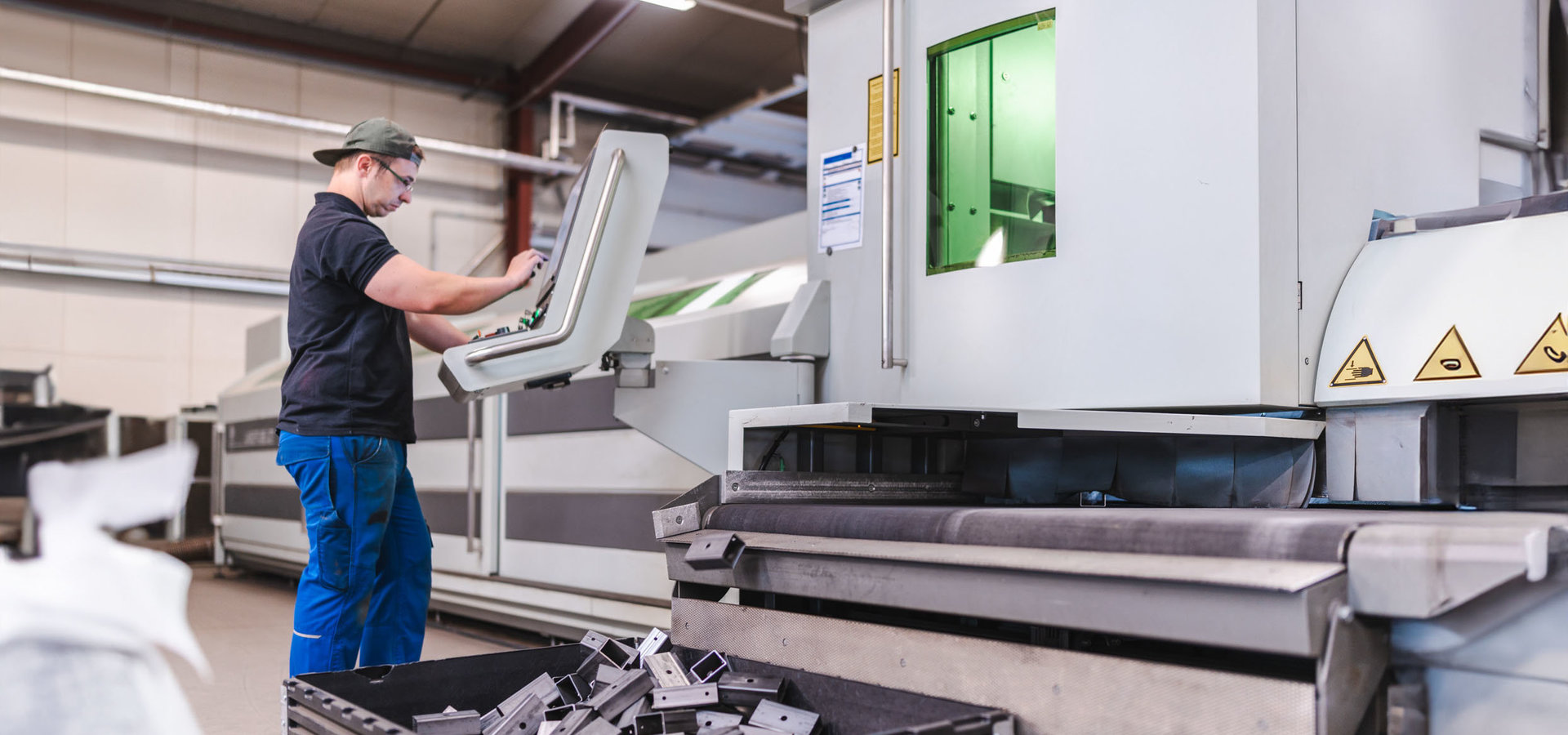 Unterschütz Mitarbeiter gibt Daten an einer 3D-Laserschneidanlage ein