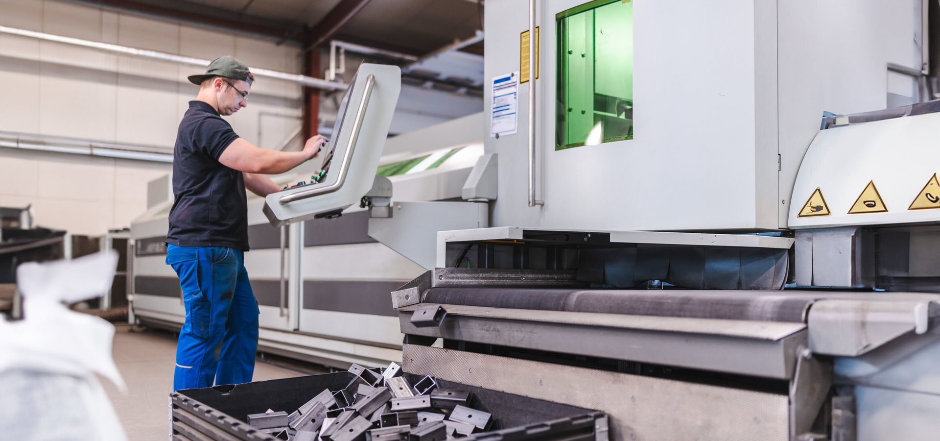 Unterschütz Mitarbeiter gibt Daten an einer 3D-Laserschneidanlage ein